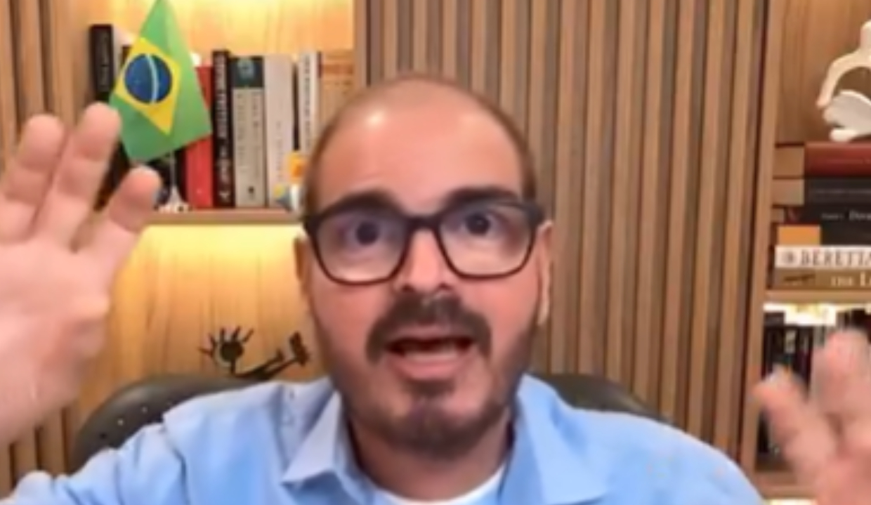 Rodrigo Constantino falando e gesticulando para a câmera, de óculos