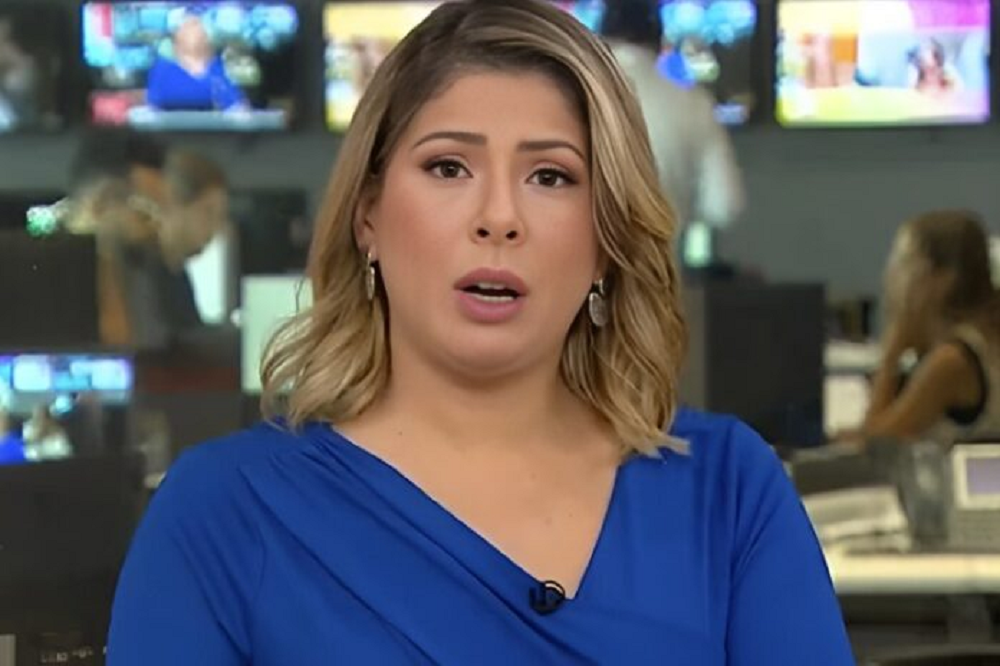 A jornalista Daniela Lima de cabelo solto e roupa azul, falando para a câmera