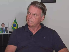 ex-presidente Jair Bolsonaro (PL) olhando para o lado, sério, de camisa azul marinho polo
