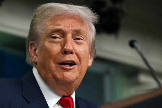Donald Trump falando com expressão debochada