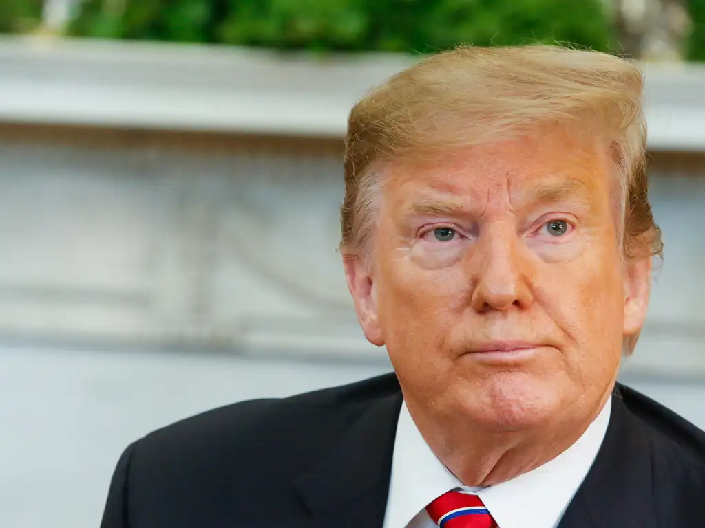 Donald Trump no canto direito de foto, sério