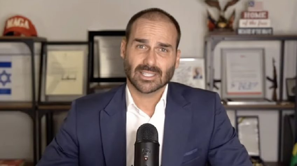 O deputado federal licenciado Eduardo Bolsonaro (PL-SP) falando para a câmera, sério