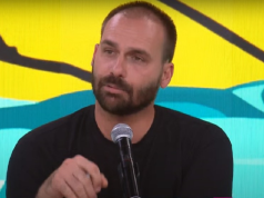 O deputado licenciado Eduardo Bolsonaro falando, sério, de roupa preta
