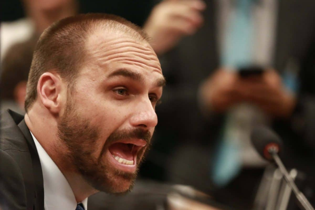 deputado federal Eduardo Bolsonaro (PL-SP) em close, de perfil, gritando