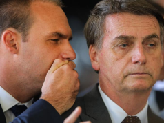 O deputado federal licenciado Eduardo Bolsonaro (PL-SP) falando no ouvido do ex-presidente Jair Bolsonaro (PL)