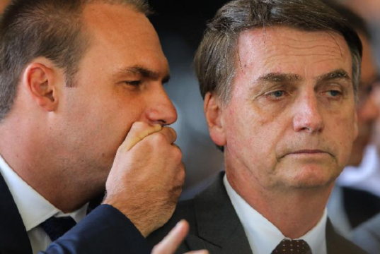 O deputado federal licenciado Eduardo Bolsonaro (PL-SP) falando no ouvido do ex-presidente Jair Bolsonaro (PL)
