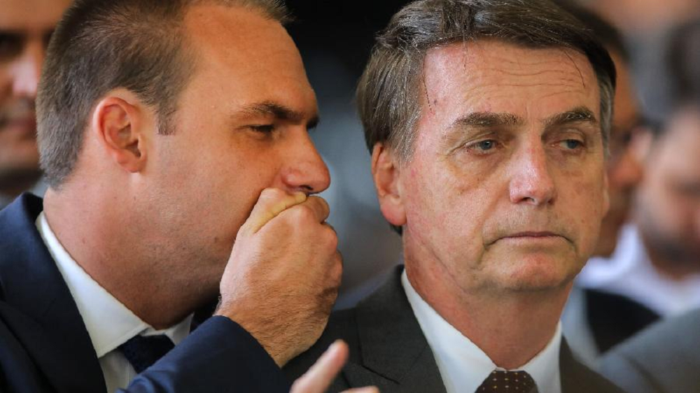 O deputado federal licenciado Eduardo Bolsonaro (PL-SP) falando no ouvido do ex-presidente Jair Bolsonaro (PL)