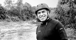 O ex-prefeito de Quebrangulo Marcelo Lima em foto em preto e branco, sorrindo, com roupa de banho e capacete