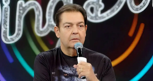 O apresentador Fausto Silva segurando microfone, com expressão incrédula
