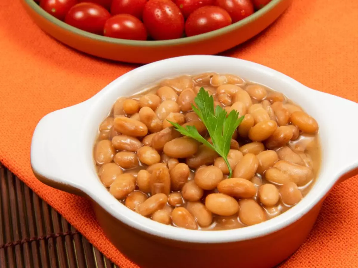 Tigela com feijão carioca e tomates cereja ao fundo