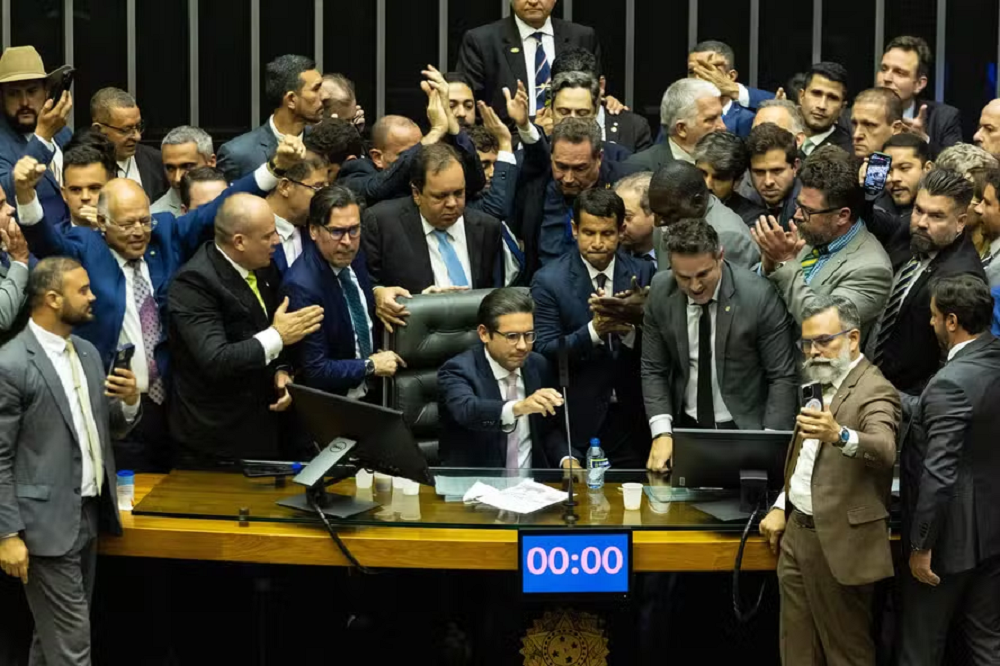 Hugo Motta após reassumir cadeira ainda cercado de parlamentares de oposição que fizeram motim