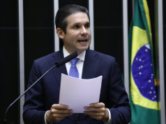 Hugo Motta (Republicanos-PB) falando em microfone e segurando papel