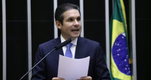 Hugo Motta (Republicanos-PB) falando em microfone e segurando papel
