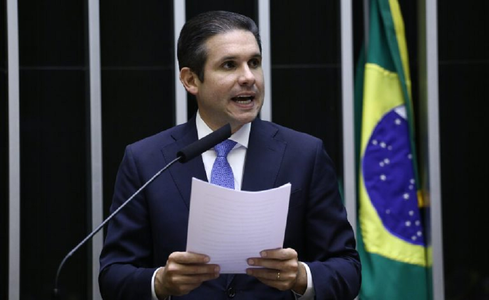 Hugo Motta (Republicanos-PB) falando em microfone e segurando papel