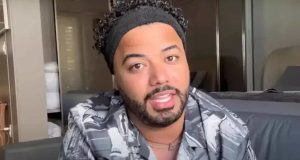 Hytalo Santos de roupa cinza e faixa preta na cabeça, falando para a câmera