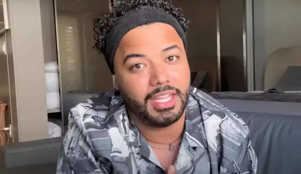 Hytalo Santos de roupa cinza e faixa preta na cabeça, falando para a câmera