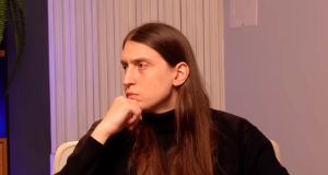 Felipe Bressanim Pereira, mais conhecido como Felca, de roupa preta e cabelo solto, sério, olhando para o lado