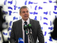 Lindbergh Farias falando em microfones, sério, olhando para o lado