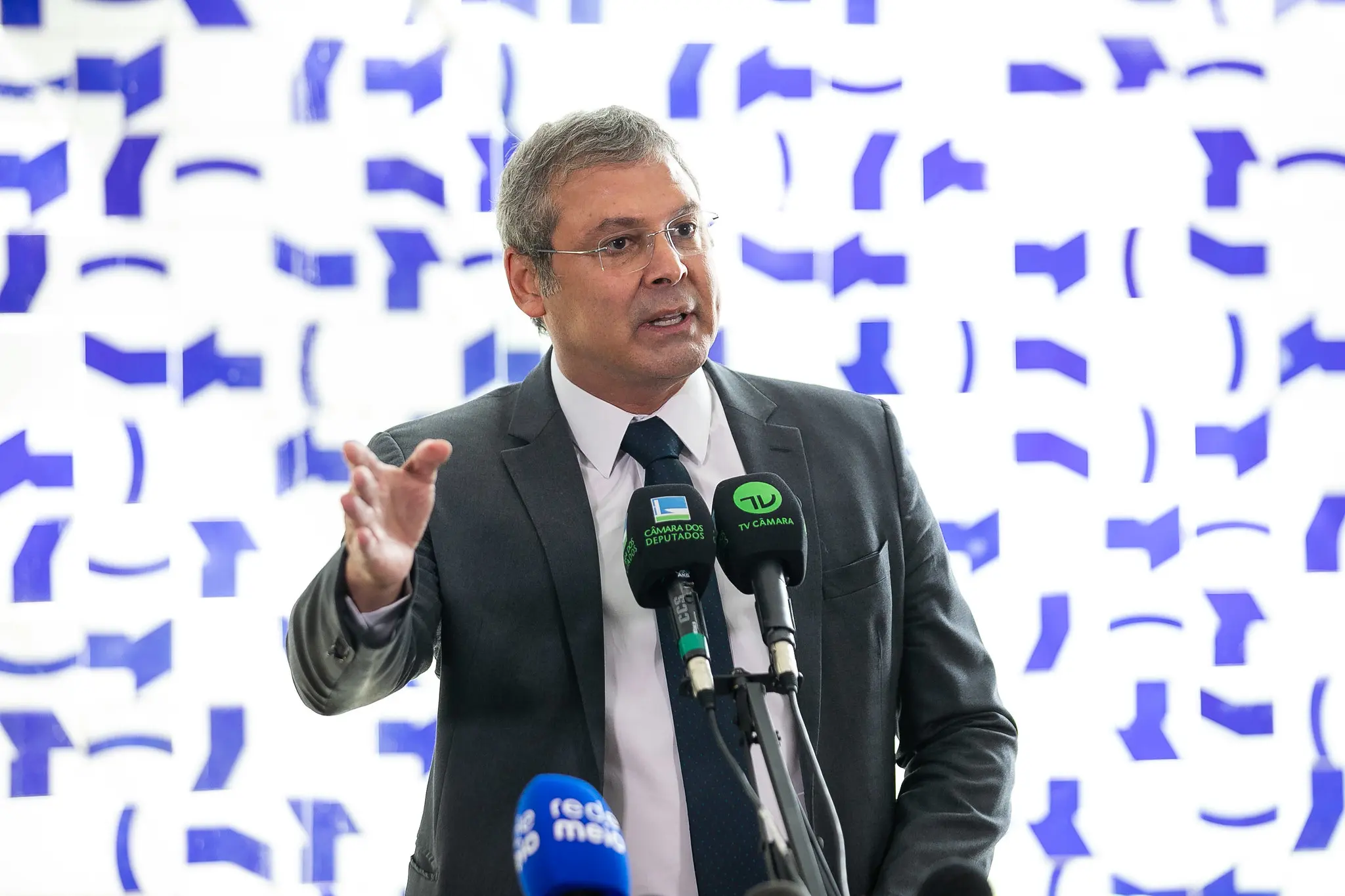 O líder do PT na Câmara dos Deputados, Lindbergh Farias (RJ), em pé, falando em microfone e gesticulando, sério, sem olhar para a câmera, de óculos