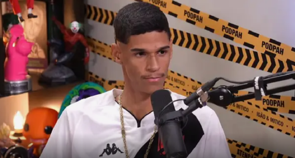 O influenciador Iran Ferreira, mais conhecido como Luva de Pedreiro, sério, perto de microfone, sem olhar para a câmera