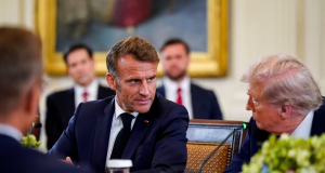 O presidente da França, Emmanuel Macron, e o presidente dos Estados Unidos, Donald Trump conversando sentados à mesa, sérios, lado a lado