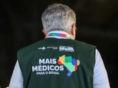 O ministro da Saúde, Alexandre Padilha, de costas com o colete do Mais Médicos