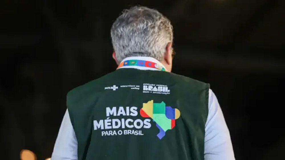 O ministro da Saúde, Alexandre Padilha, de costas com o colete do Mais Médicos