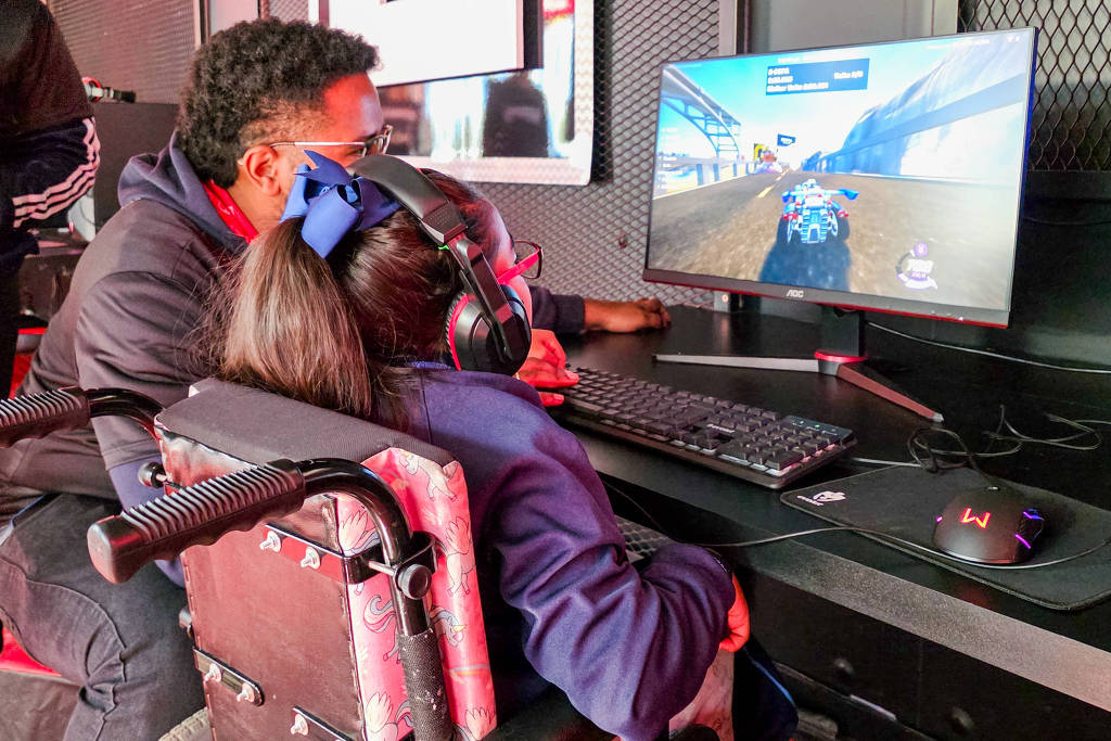 Jovens mexendo no computador, de costas para a câmera