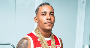 Marlon Brendon Coelho Couto da Silva, conhecido como MC Poze do Rodo, sério, de cordões de ouro e camiseta vermelha e branca, olhando para a câmera