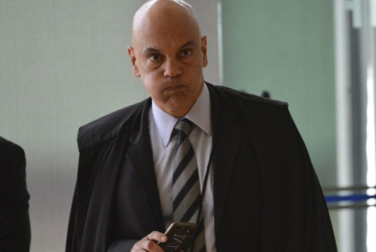 O ministro Alexandre de Moraes, do Supremo Tribunal Federal (STF), com a boca cheia de ar, sério, em pé, andando e olhando pra frente