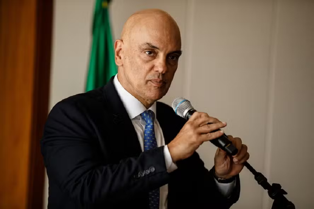O ministro Alexandre de Moraes sério, falando em microfone