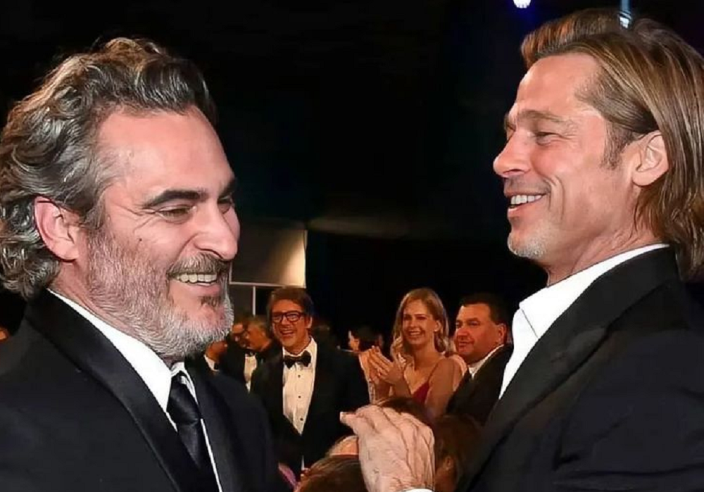 Joaquin Phoenix e Brad Pitt rindo sem olhar para a câmera