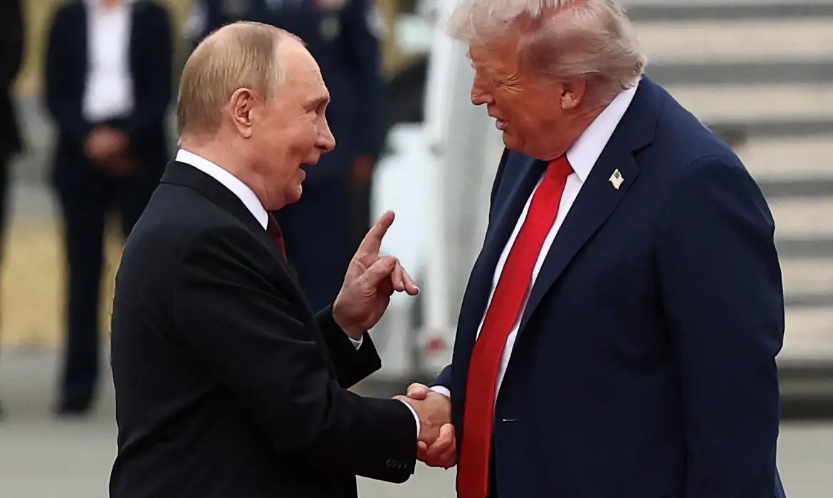 O presidente russo, Vladimir Putin, e o presidente norte-americano, Donald Trump, conversando e dando aperto de mãos , sérios