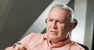 fundador da Ultrafarma, Sidney Oliveira, de camisa cor de rosa, falando e gesticulando, sério, sem olhar para a câmera