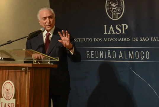 O ex-presidente da República Michel Temer em pé, falando em microfone e gesticulando
