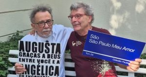O cantor Tom Zé e o vereador Nabil Bonduki (PT) sentados lado a lado com placas