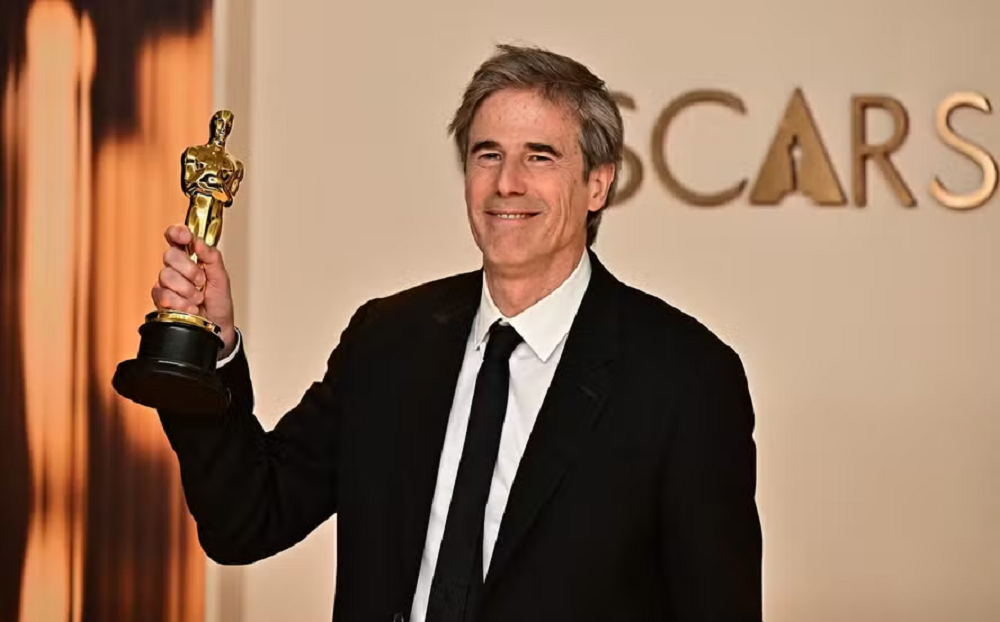 Walter Salles Jr., diretor premiado do filme Ainda Estou Aqui, sorrindo e segurando estatueta do Oscar