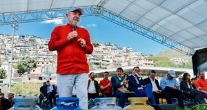 O presidente Luiz Inácio Lula da Silva (PT) durante agenda em Minas Gerais, de roupa vermelha e chapéu, falando, perto de bujões de gás