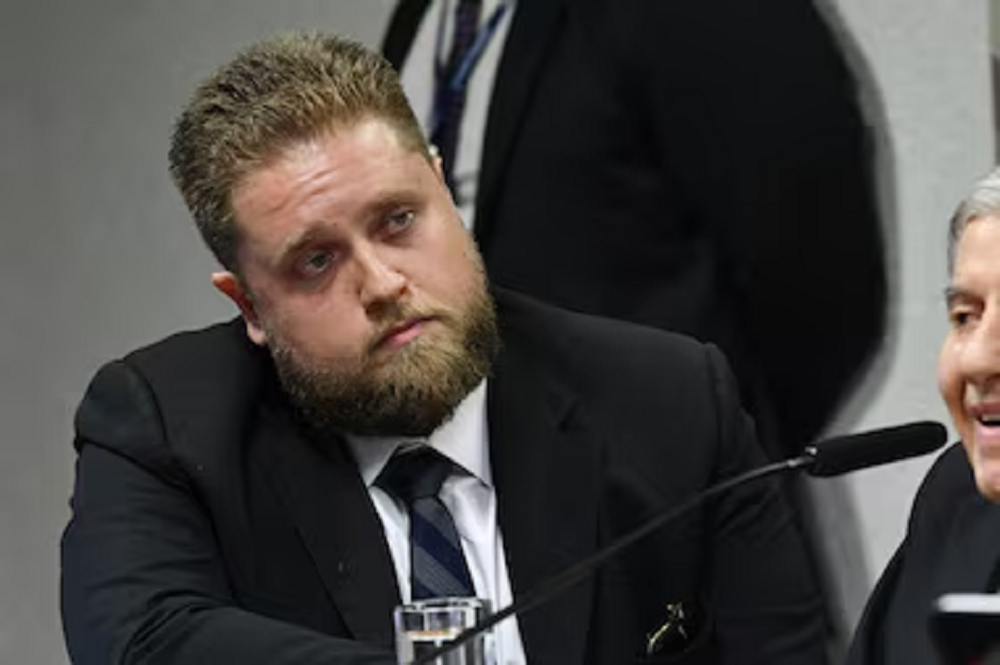 O advogado Matheus Milanez sério, sem olhar para a câmera