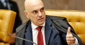 Alexandre de Moraes, ministro do Supremo Tribunal Federal (STF), olhando para o lado e fazendo sinal de joia