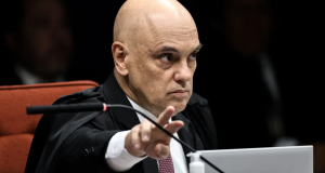 ministro Alexandre de Moraes apontando pra frente, sério, sem olhar para a câmera, em close
