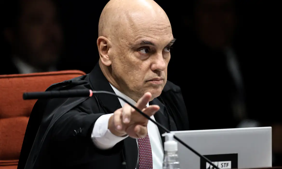 ministro Alexandre de Moraes apontando pra frente, sério, sem olhar para a câmera, em close