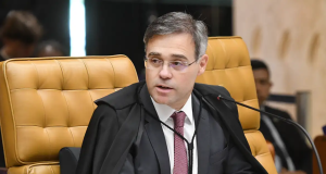 O ministro André Mendonça de óculos, olhando para o lado, sério