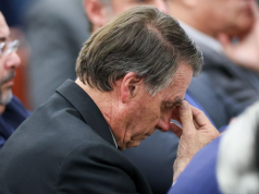 ex-presidente Jair Bolsonaro (PL) de cabeça baixa, sério, com a mão no rosto