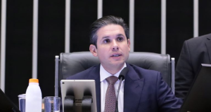 O presidente da Câmara dos Deputados, Hugo Motta, falando e olhando para o lado