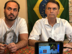 O vereador Carlos Bolsonaro (PL-RJ) e o ex-presidente Jair Bolsonaro (PL) sentados lado a lado, sérios, sem olhar para a câmera