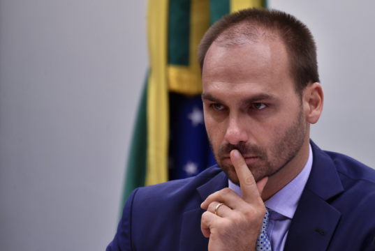 deputado Eduardo Bolsonaro (PL-SP) com expressão pensativa, sério, no canto direito de foto