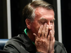 Jair Bolsonaro (PL) com as mãos no rosto, em close, de olhos fechados, sério