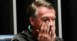 Jair Bolsonaro (PL) com as mãos no rosto, em close, de olhos fechados, sério