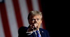 Donald Trump apontando pra frente, sério